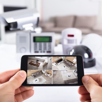 Close-up,Of,A,Person's,Hand,Holding,Mobile,Phone,With,Cctv